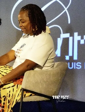 Une femme en tee-shirt blanc, assise sur scène lors de la Journée mondiale de la trisomie 21
